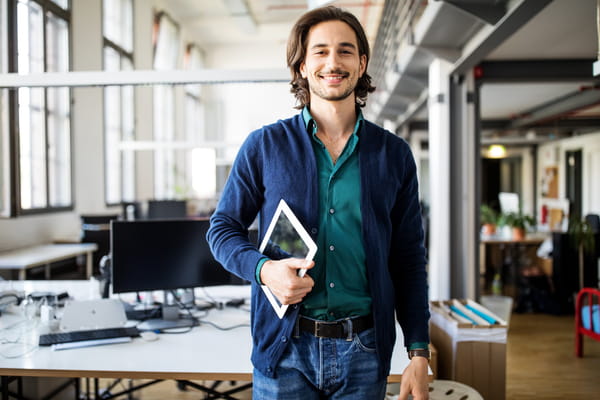 Medarbejder holder tablet med et smil