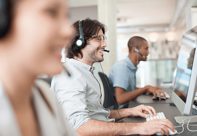 Man laughing at computer during business call