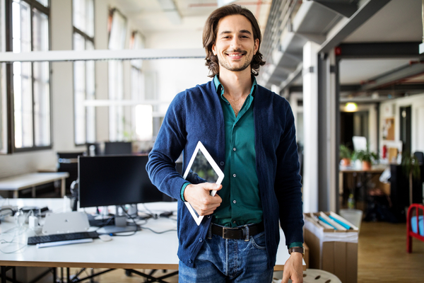 Employé souriant tenant une tablette